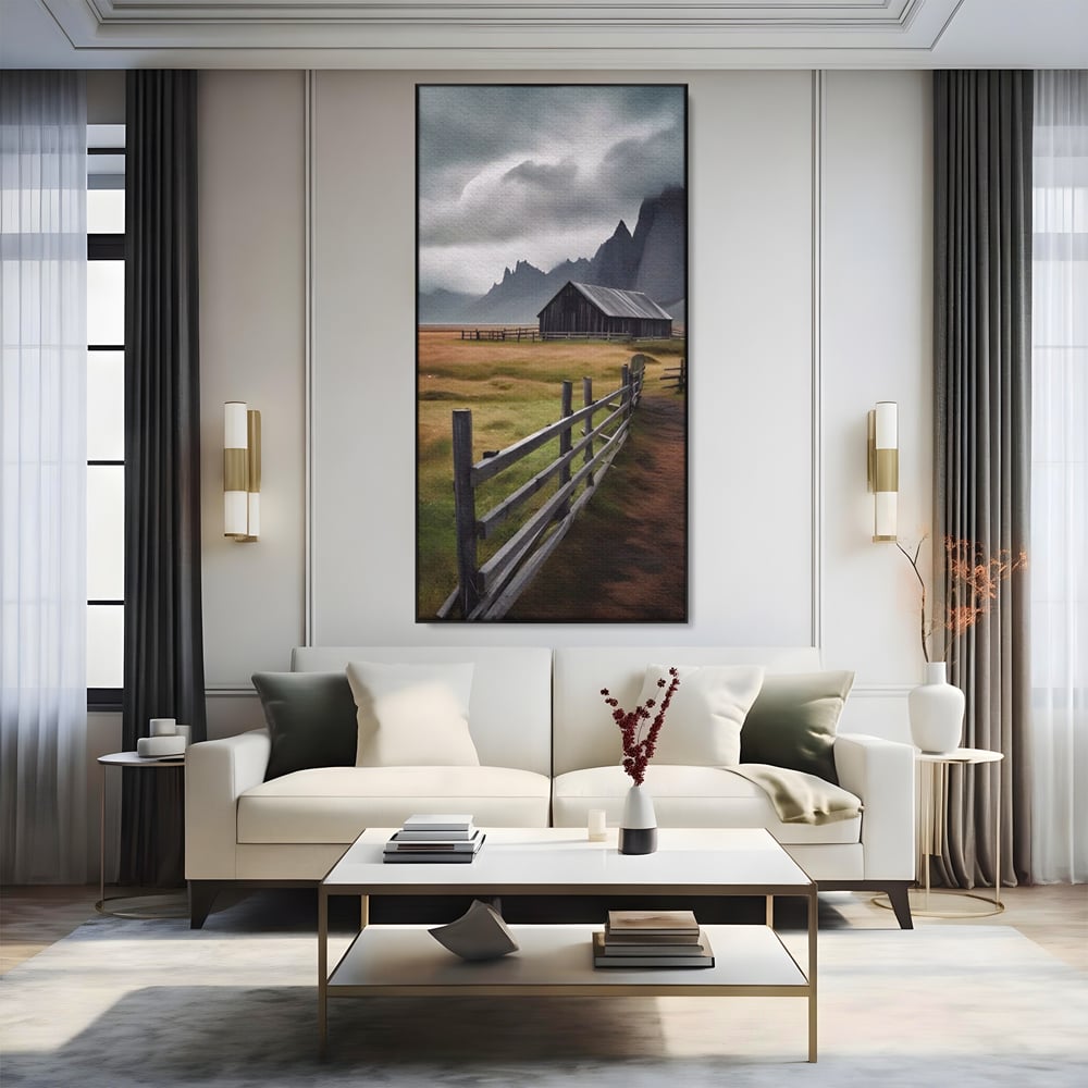 Tablou canvas cu tablou cu peisaj montan si gard de lemn, in rama de aluminiu negru, pe perete intr-un living